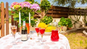 A table set outdoors with a bottle of wine, glasses, a pitcher of red drink, and a bowl of fruit. - Villa Constantinos - Three Bedroom Villa, Sleeps 6 (Agia Marina Chrysochous)