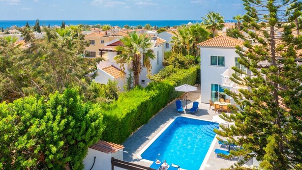 Un quartier résidentiel doté d’une piscine, de maisons et offrant une vue sur la mer.