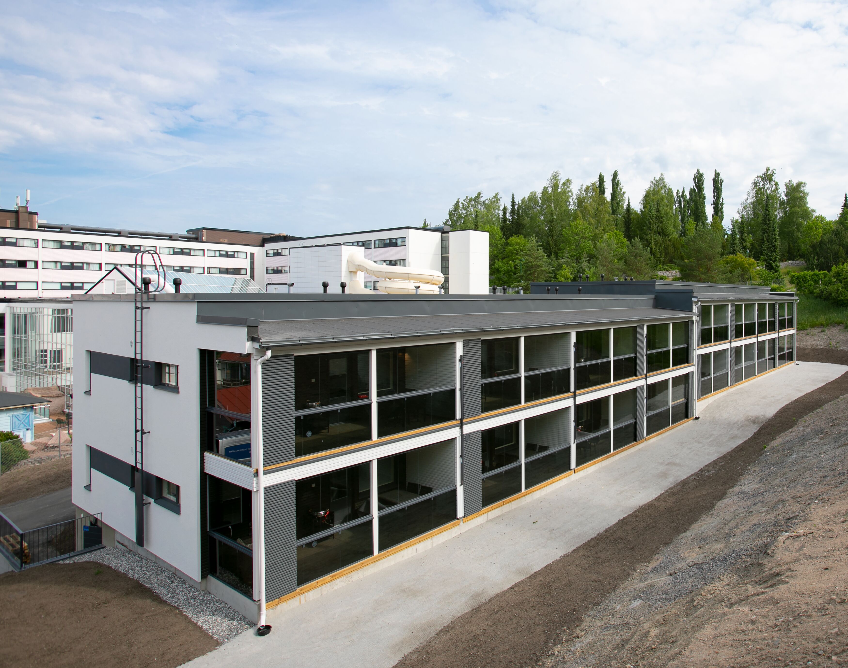 Un edificio moderno con techo plano, ventanas amplias y base de hormigón.