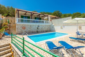 Un bâtiment en pierre doté d’une piscine, d’un espace extérieur aménagé et d’un escalier.