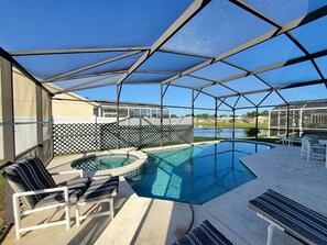 A covered outdoor swimming pool with lounge chairs and a hot tub. - The perfect house! (Clermont)