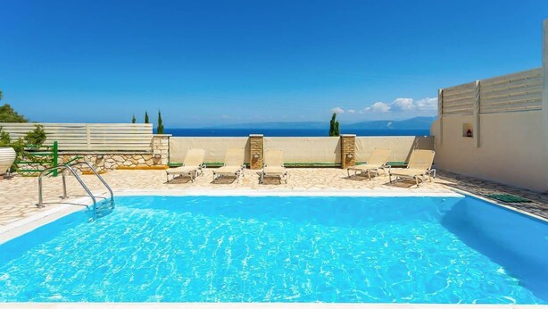 A swimming pool with lounge chairs and a view of the sea. - Villa Anastasia - Three Bedroom Villa, Sleeps 6 (Paxi)