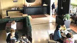 Eine moderne Lobby mit einer Rezeption, einer Sitzecke und einer grünen Wand.