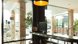 Eine moderne Bar mit Glastrennwand, zwei Pendelleuchten und einem Fernseher.