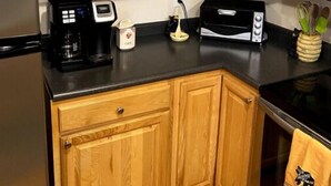 A kitchen with wooden cabinets, a coffee maker, a toaster, and a kettle. - Paradise Peak - Tranquility and majestic splendor! (Butler)