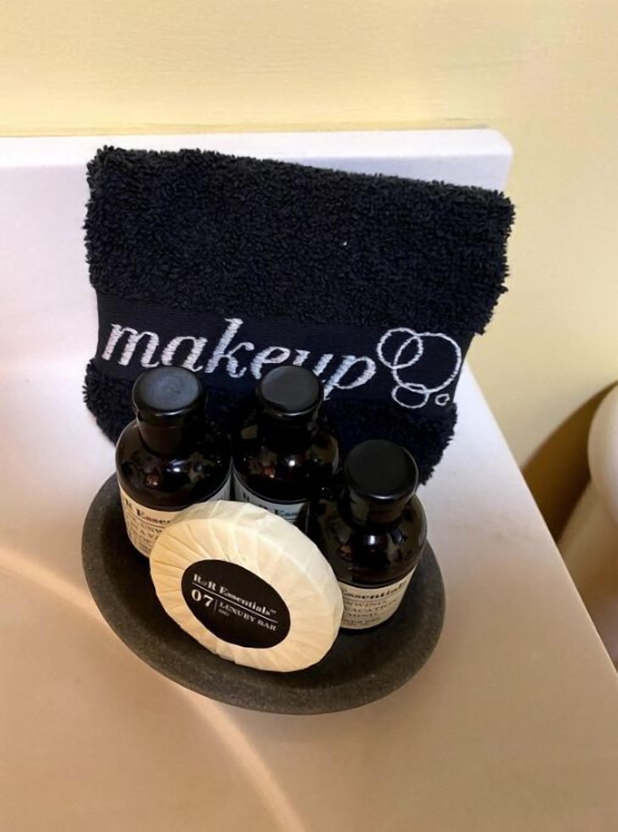 A makeup station with a towel labeled 'makeup' and several bottles of products.