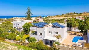 Eine moderne Villa mit Solaranlage, Pool und Meerblick.