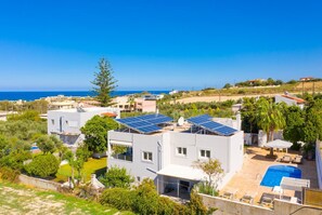 Eine moderne Villa mit Solaranlage, Pool und Meerblick.