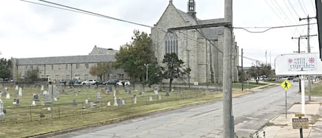 A cemetery with headstones, a church with a tall steeple, and a sign for 'sara cupcakes'.