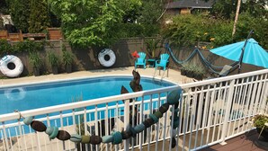 A swimming pool with a white fence, blue chairs, and a blue umbrella. - Ultimate Pool House – 5 Kings, Near Beach and Wineries (Penticton)