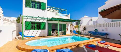 Et oppvarmet basseng og solsenger