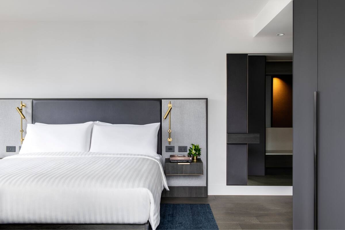 A modern bedroom with a large bed, bedside tables, and a nightstand.