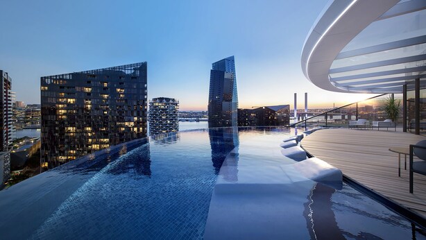 A rooftop infinity pool with a city view, modern architecture, and a wooden deck with seating.