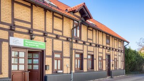 A traditional building with a sign for Physiotherapie Ziesing, featuring a large wooden door and multiple windows. - A beautiful home (Gernrode)