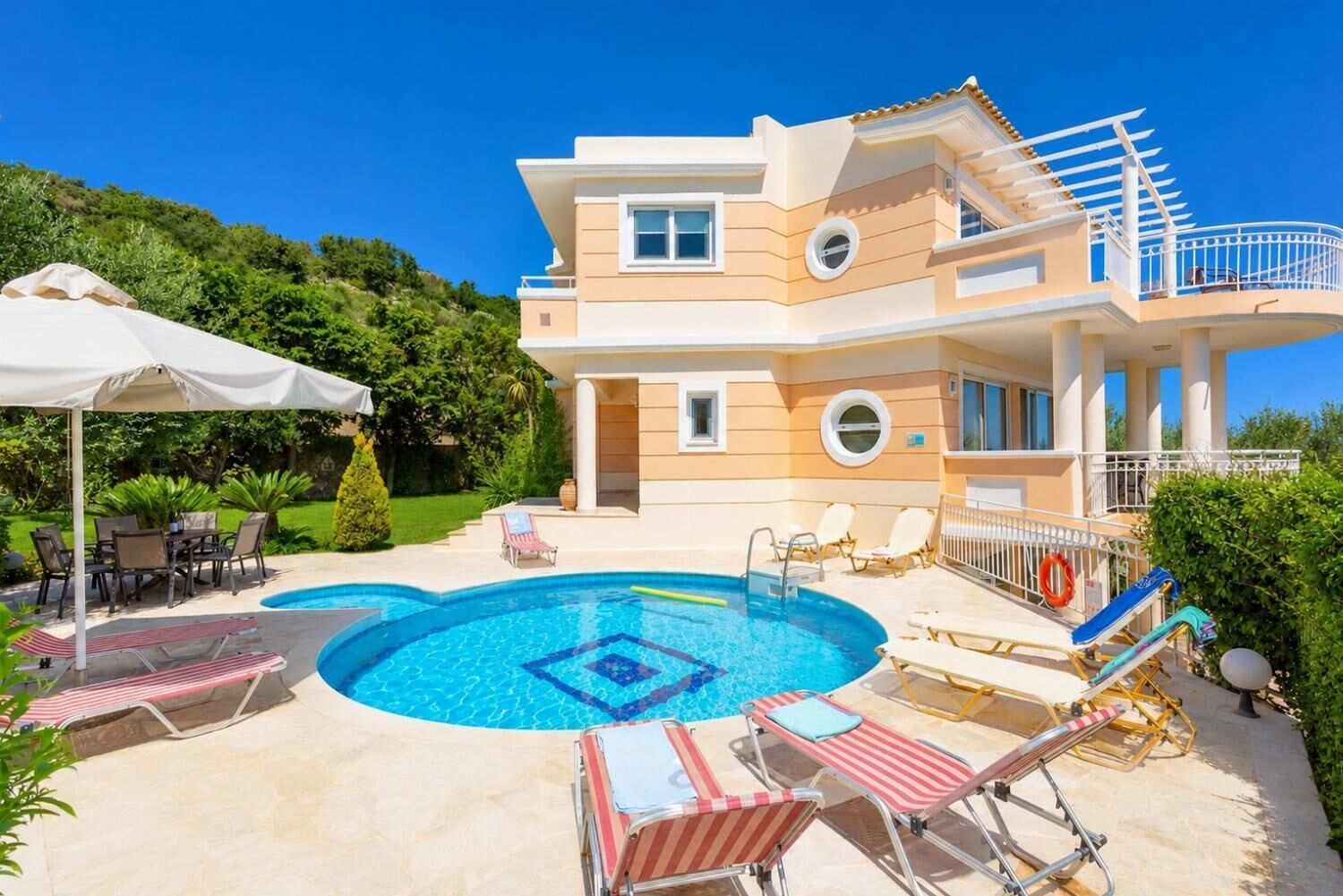 A two-story house with a swimming pool, outdoor furniture, and a balcony.