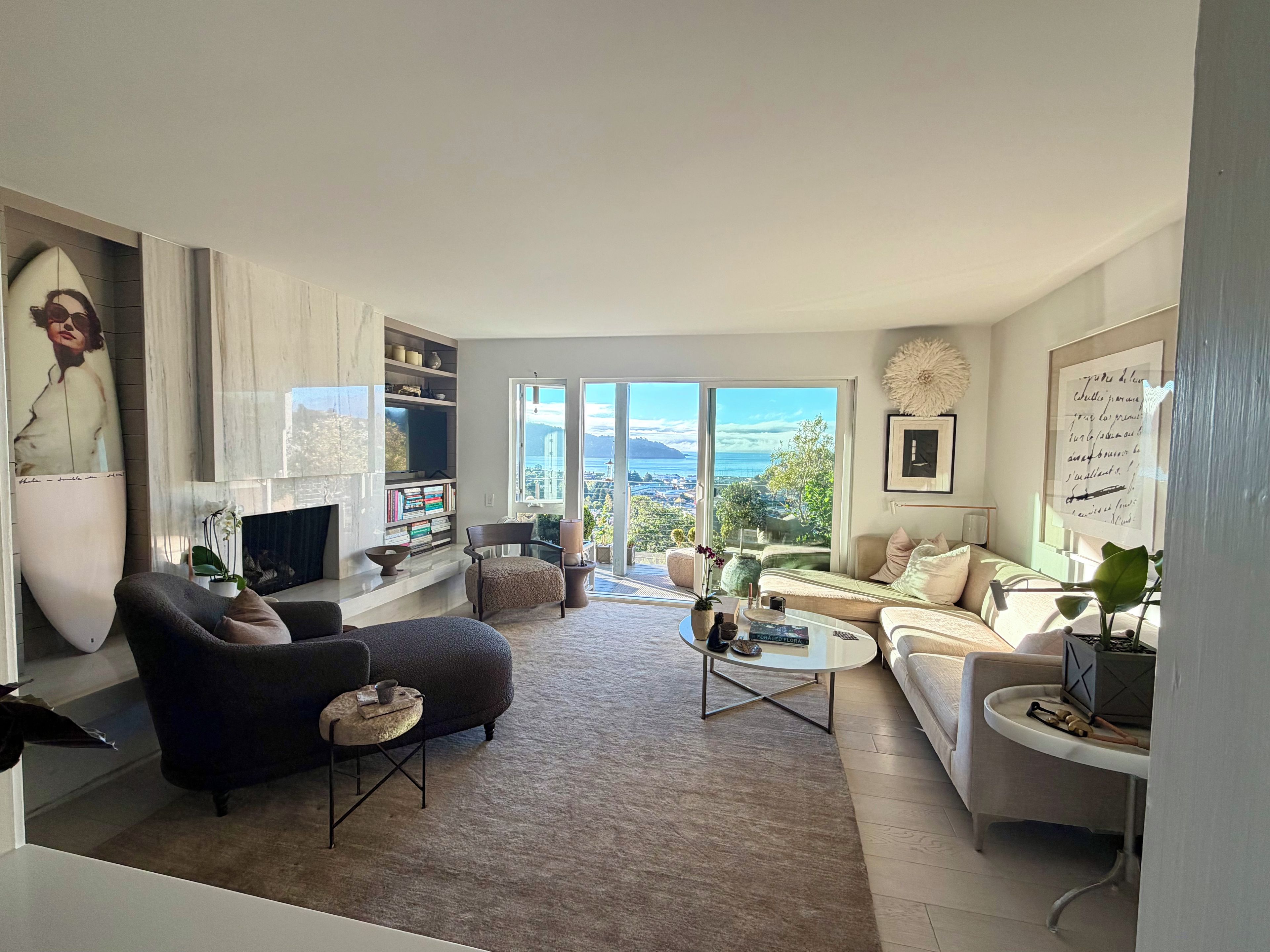 A modern living room with a fireplace, seating area, and a view of the city.