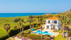 Une maison à deux étages avec une piscine et une vue sur la mer.