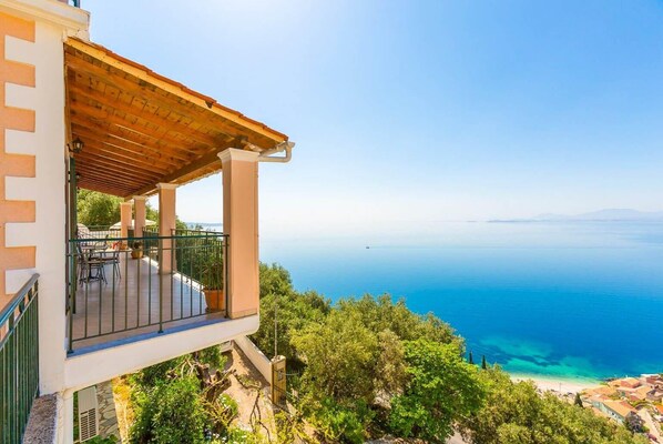 Ein Balkon mit Holzdach und Blick auf die Küste.