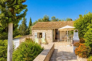A stone house with a tiled roof, a patio with outdoor furniture, and a grill. - Millers Cottage Large Private Pool, A/C, WiFi (Paxi)