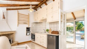 Una cocina moderna con armarios blancos, horno empotrado y lavavajillas.