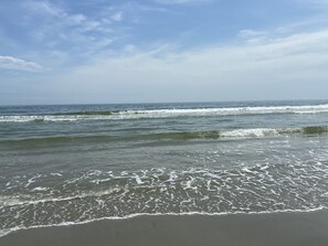 Une plage où les vagues viennent doucement lécher le rivage.