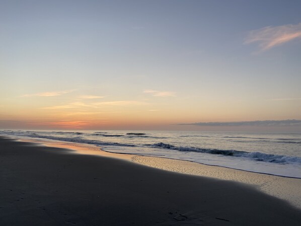 Une plage avec une mer calme et un ciel dégagé.