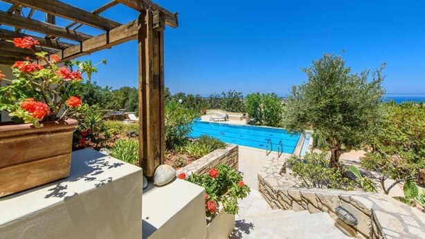 A pool area with a pergola, stone steps, and potted plants. - Villa Eleni (Hersonissos)