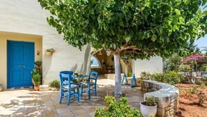 A patio with a blue door, a tree, and outdoor furniture. - Villa Eleni (Hersonissos)