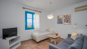 A modern room with a bed, a sofa, a TV on a stand, and artwork on the wall. - Villa Eleni (Hersonissos)
