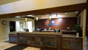 A reception desk with a 'TravelShare' mat, a clock, and a 'WYNDHAM' sign. - Beautiful Steamboat Springs Resort (Steamboat Springs)