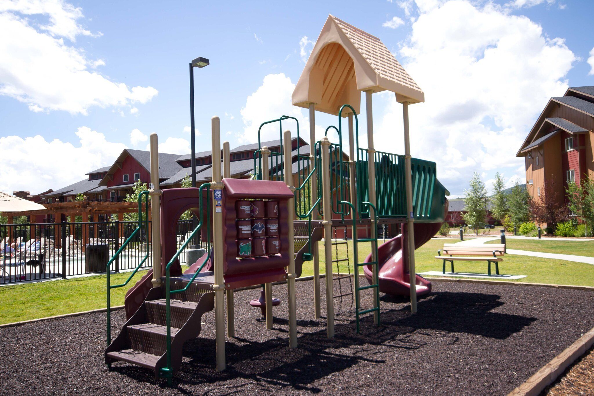A playground with a slide, climbing area, and a small shelter.