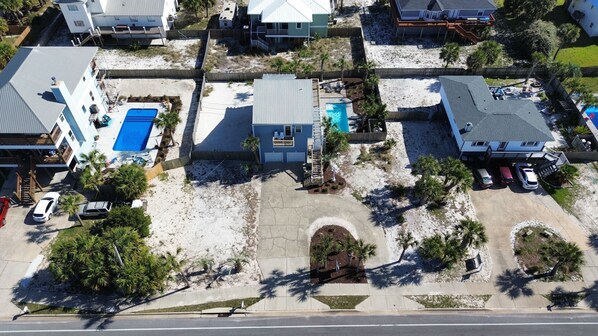 Vista aérea de una zona residencial con casas, una piscina y un estacionamiento.