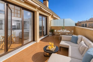 En moderne lejlighed med balkon, spiseplads og sofa.