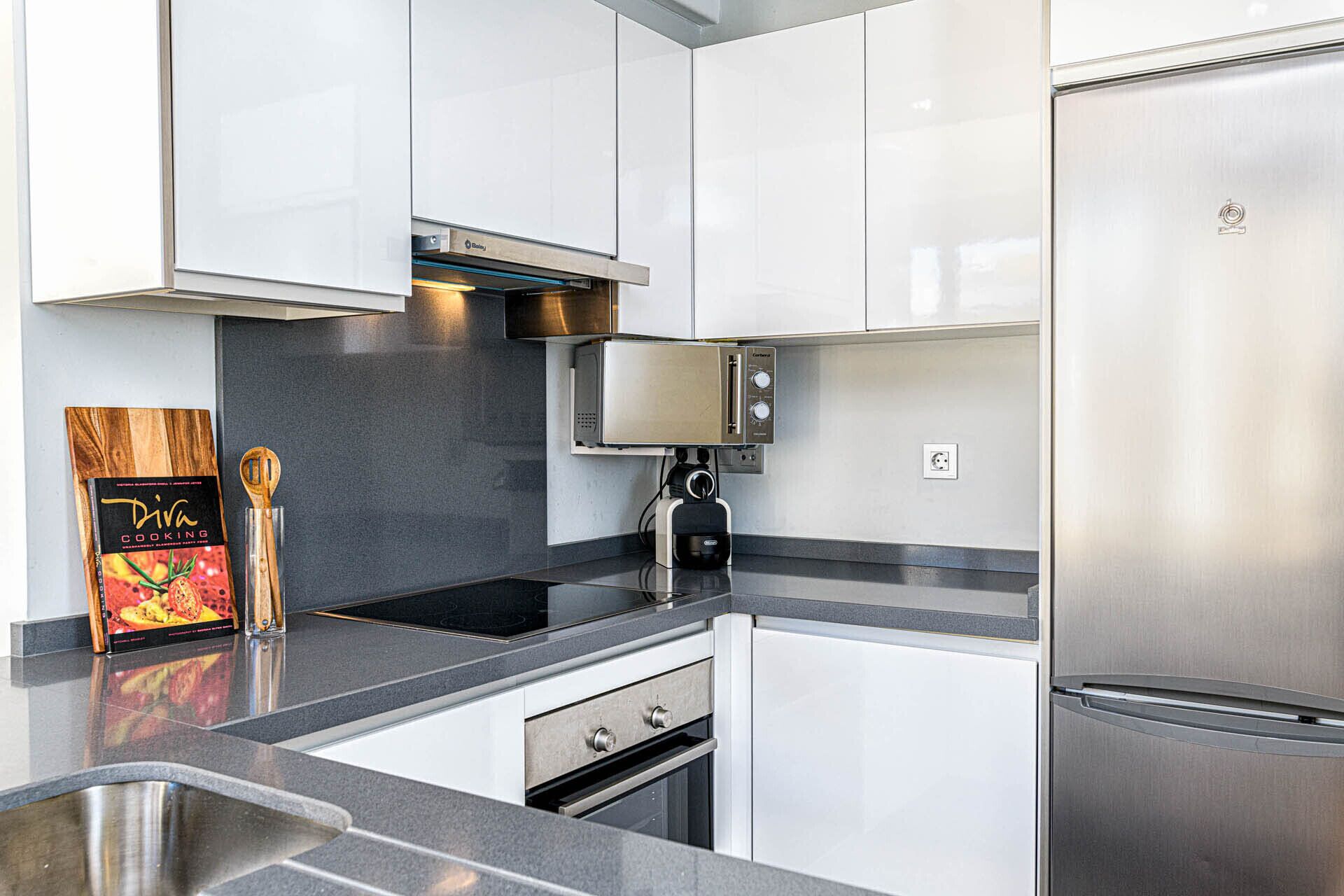 Une cuisine moderne équipée d’appareils électroménagers en acier inoxydable, d’un four encastré et d’un four à micro-ondes.
