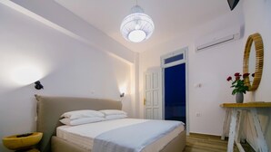 A bedroom with a bed, bedside tables, a mirror, and a chandelier.