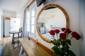 Relax in this serene space with a comfortable bed, a large mirror, and a cozy bench.