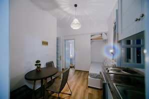 Enjoy cooking and dining in this modern kitchen and dining area, featuring an oven, stovetop, and round table.