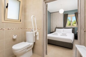 Une salle de bain équipée de toilettes, d’un bidet et d’un miroir.