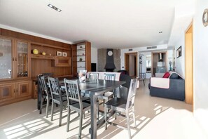 Une cuisine moderne avec un coin repas, des meubles en bois et un four encastré.