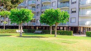 A courtyard with trees, benches, and a building with balconies. - Residential Costamar Playa, with swimming pools near Bcn (Cabrera de Mar)