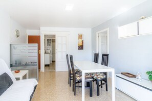 A compact room with a bed, a dining table with chairs, a whiteboard, and a small kitchenette. - Residential Costamar Playa, with swimming pools near Bcn (Cabrera de Mar)