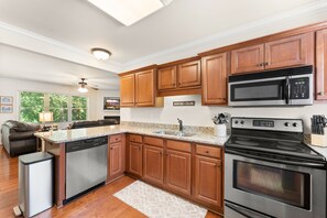 A modern kitchen with wooden cabinets, stainless steel appliances, and a built-in dishwasher. - Chattahoochee River House 1 - Decorated for Christmas! (Helen)