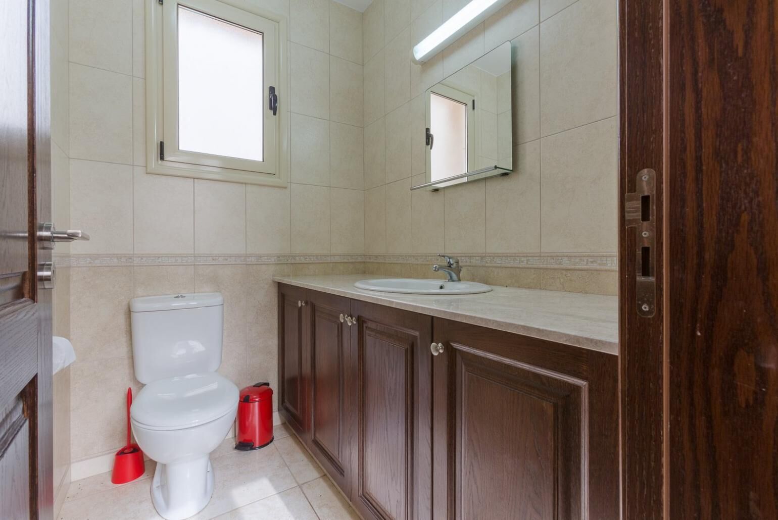 Ein Badezimmer mit Toilette, Waschbecken und Holzschränken.