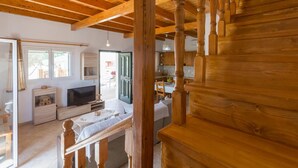 Eine Holztreppe führt zu einem Essbereich mit Tisch und Stühlen.