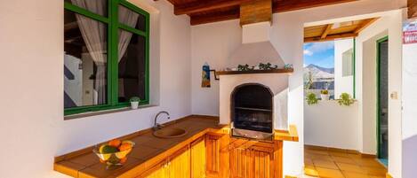 A kitchen with a wooden counter, a sink, and a built-in grill.