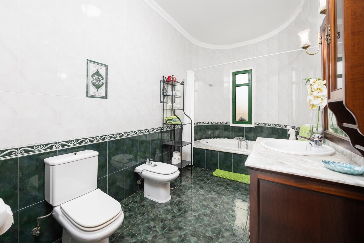 Une salle de bain équipée de toilettes, d’un bidet et d’une baignoire.
