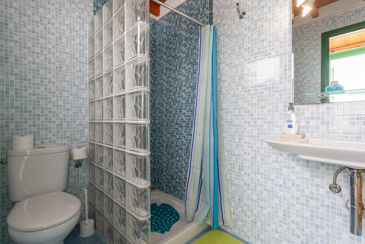 Un baño con ducha, inodoro y lavabo.