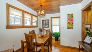 Un comedor con muebles de madera, un candelabro y una pared con un cuadro enmarcado y paneles decorativos.