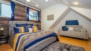 Un dormitorio con cama, sofá, alfombra y pared de madera.