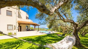 A house with a swimming pool, a hammock, and a view of the sea. - Villa Armi - Four Bedroom Villa, Sleeps 8 (Pirgos)